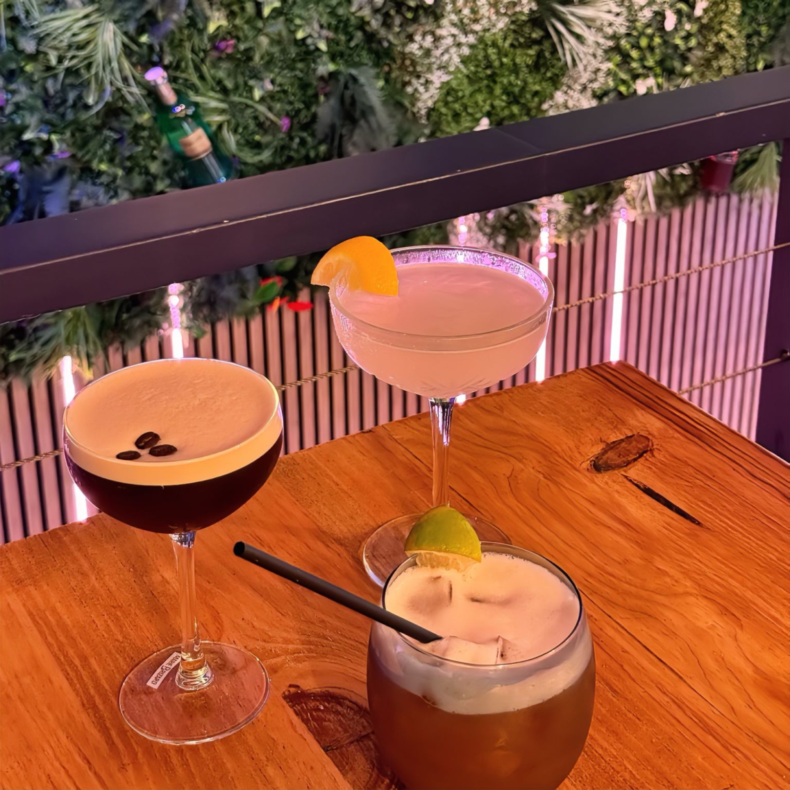 Trois cocktails colorés avec des garnitures de fruits.